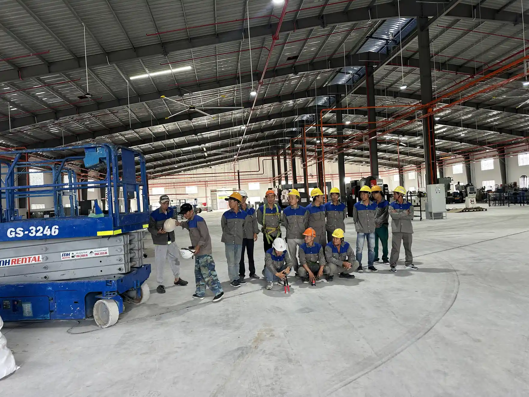 Đội thi công điện và xe nâng người tại nhà xưởng