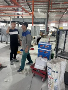 Nhân sự trao đổi tại khu vực máy móc trong nhà xưởng