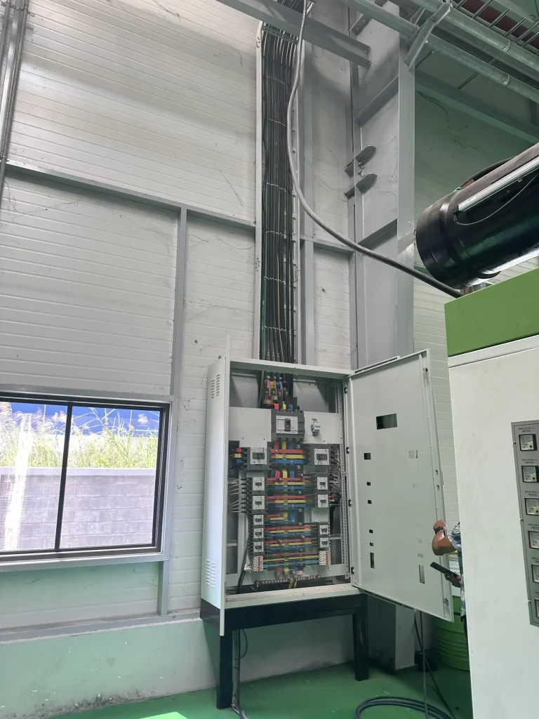 Tủ điện phân phối đặt sát tường nhà xưởng, cáp đi lên máng trên cao